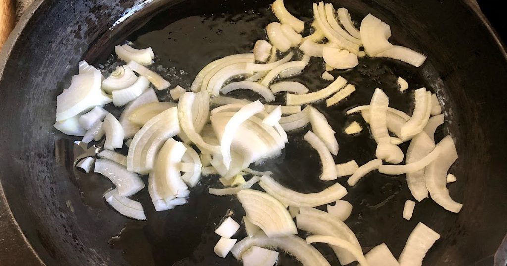Sauteeing onion in a cast iron skillet over medium heat.